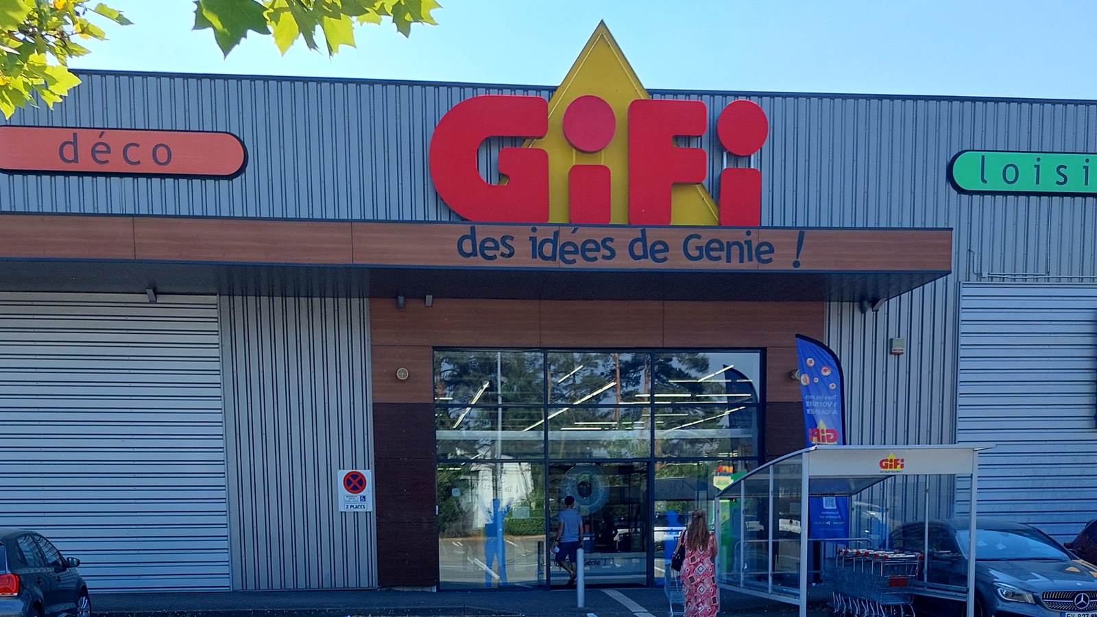 Façade d'un magasin Gifi en zone commerciale, avec le logo rouge et jaune, le slogan « des idées de Génie ! » et des clients qui entrent